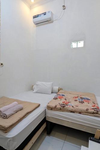 two beds sitting next to each other in a room at Casa de Vie Homestay in Malang