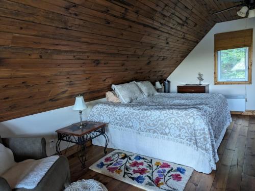 a bedroom with a bed and a wooden ceiling at Eagle Nest Cottage in Val des Monts