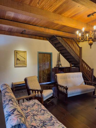 a living room with two chairs and a couch at Casa Enxaimel Aurora in Pomerode