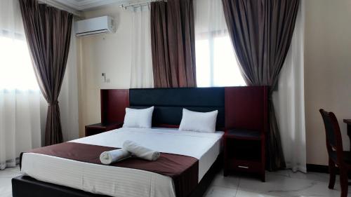 a bedroom with a large bed with curtains at Melias Hotel Diamniadio in Dogar