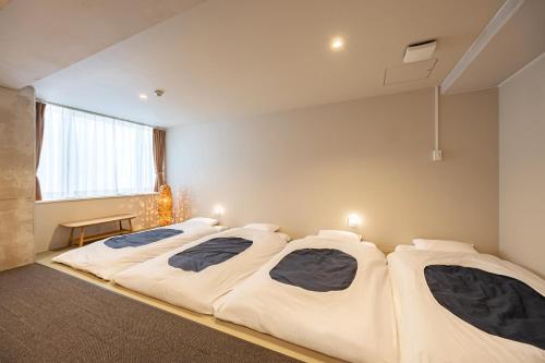 a room with three beds in a room at GRAND HOSTEL LDK Tokyo Nishikasai -GRAND OPENING In May 2025- in Tokyo