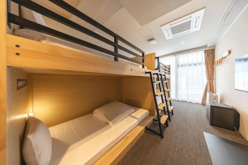 a bunk bed in a room with a desk at GRAND HOSTEL LDK Tokyo Nishikasai -GRAND OPENING In May 2025- in Tokyo