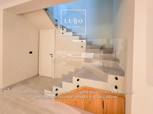 a staircase in a room with a glass wall at Lusso Villa - San Pietro Melia in Draçi