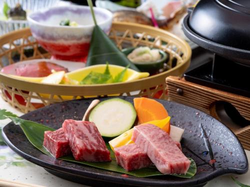 a plate of food with meat and vegetables on a table at Oyado Tsuruya in Matsumoto