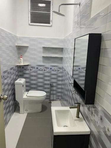 a bathroom with a toilet and a sink and a mirror at Homestay Aman Berkat in Kampar