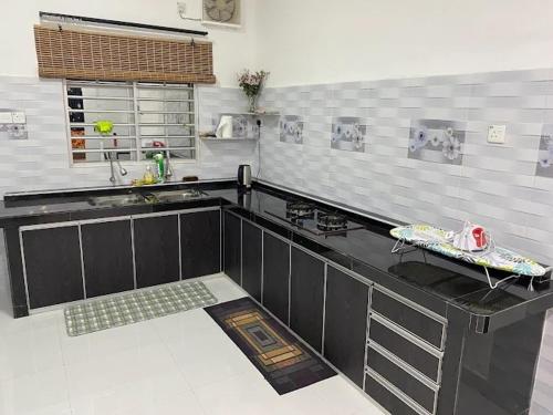 a kitchen with a black counter top in a room at Homestay Aman Berkat in Kampar