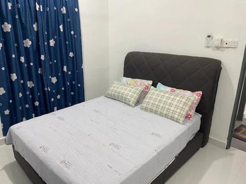 a bed with pillows on it in a bedroom at Homestay Aman Berkat in Kampar