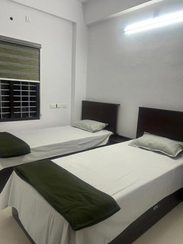 a bedroom with two beds and a window at Samriddhi Homestay in Trivandrum