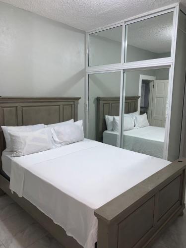 una camera da letto con due letti e un grande specchio di Border love apt 3 a Kingston