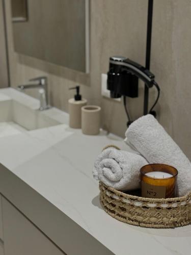 a bathroom with a basket of towels on a sink at Coastal Luxe Retreat Durres in Durrës