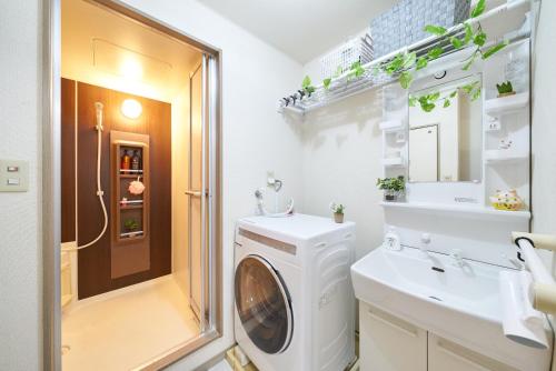 a bathroom with a washing machine and a sink at AO101 - Tokyo Stay Spacious Apartment Direct Train to Narita & Asakusa in Tokyo
