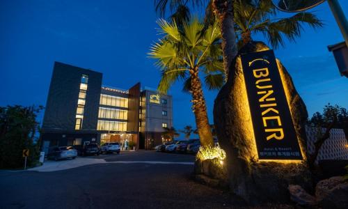 a hotel with a sign in front of a building at Jeju BunkerHotel&Resort in Seogwipo