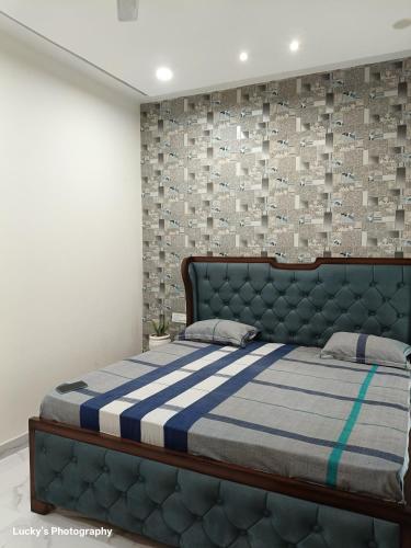 a bedroom with a bed with a blue and white blanket at BELLA VISTA Homestay BNB in Zirakpur