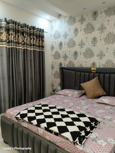 a bedroom with a bed with a checkeredkered at BELLA VISTA Homestay BNB in Zirakpur