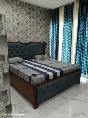 a bedroom with a bed in a room with blue curtains at BELLA VISTA Homestay BNB in Zirakpur