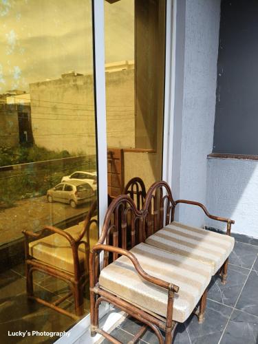 a bench on a balcony with a view of a car at BELLA VISTA Homestay BNB in Zirakpur