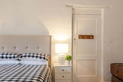 a bedroom with a bed and a lamp and a door at Tweedies Gully Estate Settlers Cottage Barossa in Williamstown
