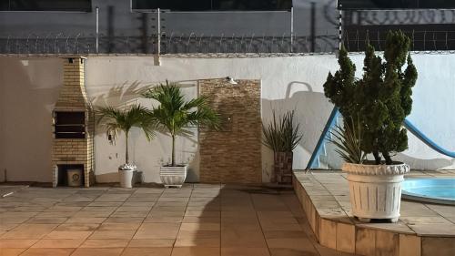 eine Terrasse mit Topfpflanzen und einem Pool in der Unterkunft Casa pra Temporada 2km da praia in São Luís