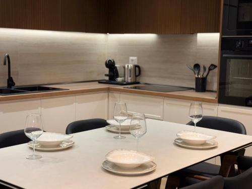 a kitchen with a table with four wine glasses at Coastal Luxe Retreat Durres in Durrës