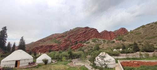 a group of tents in front of a mountain at Жибек in Dzhetyoguz