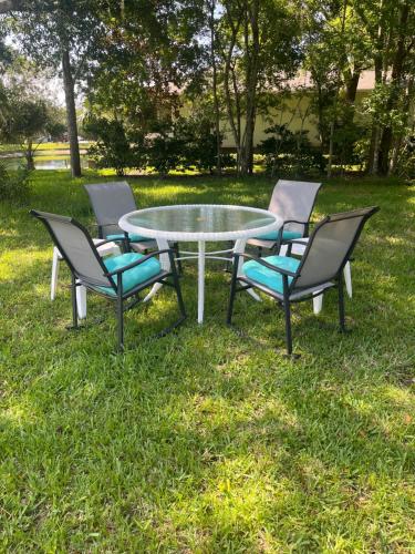 four chairs around a glass table in the grass at Cute 2 bedroom home, peaceful and so central ! in Palm Coast