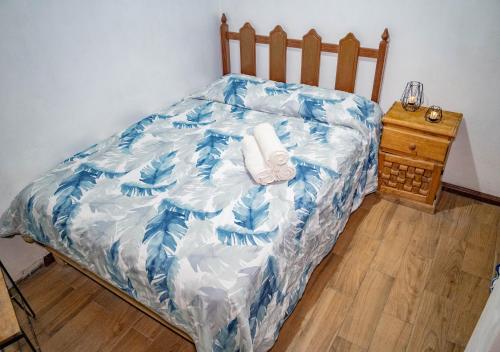 a bed with a blue and white comforter on it at Hostal Makea Pachuca in Pachuca de Soto