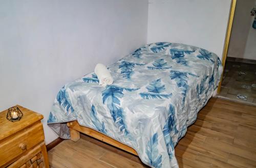 a bed covered in a blue and white comforter at Hostal Makea Pachuca in Pachuca de Soto