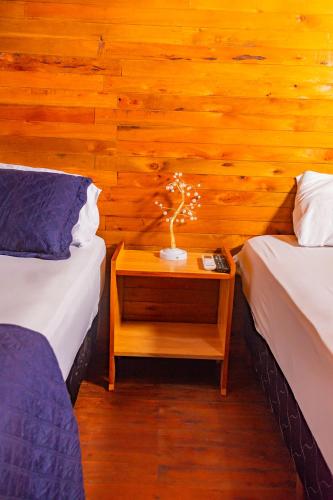 a room with two beds and a table with a plant on it at Cabaña Antonella by Renty in Encarnación