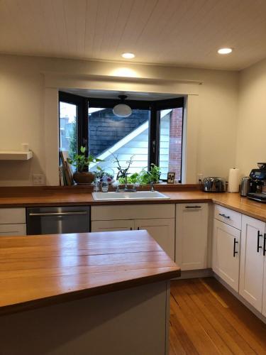 a kitchen with a wooden counter top and a window at Bright, Spacious Home with Lake & Mountain Views, Walk to Beach in Nelson