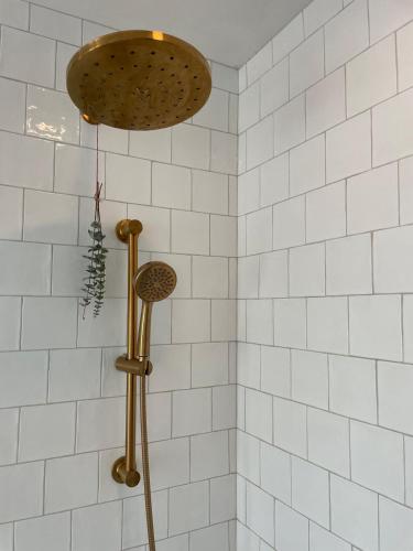 a shower in a bathroom with white tiles at Bright, Spacious Home with Lake & Mountain Views, Walk to Beach in Nelson