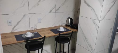 a counter with two chairs and two mugs on it at Apartamento Central in Ametista do Sul