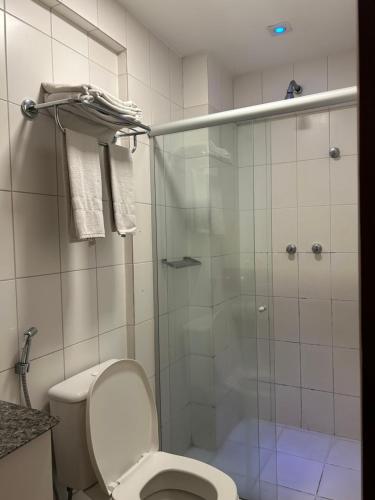 a bathroom with a toilet and a glass shower at Celita Franca Apart in Feira de Santana