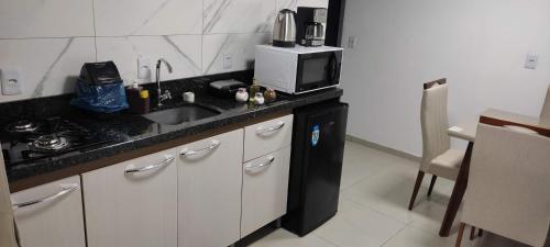 a kitchen with a sink and a microwave at Apartamento Central in Ametista do Sul