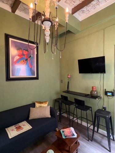 a living room with a couch and a table at Sabor Histórico, artístico, céntrico y famoso in Mexico City
