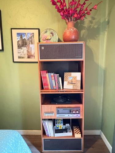 a book shelf filled with books and a vase with flowers at Sabor Histórico, artístico, céntrico y famoso in Mexico City
