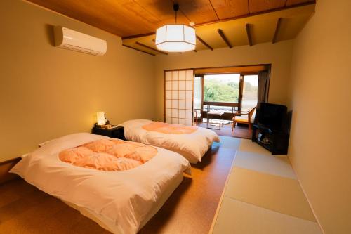 Una cama o camas en una habitación de 熱海温泉 法悦 旅館