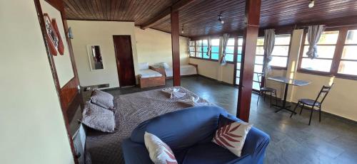 a living room with a blue couch and a table at Pousada Casa Del Mare in São Pedro da Aldeia