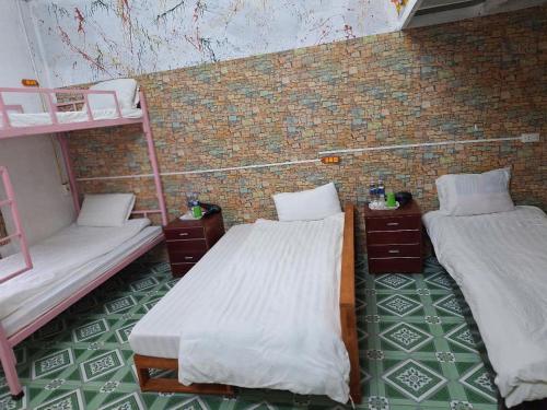 a room with two bunk beds and a brick wall at Sapa Tatu Homestay in Sa Pa