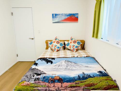 a bedroom with a bed with a painting of a mountain at Hao Bros Home Gemini A in Tokyo