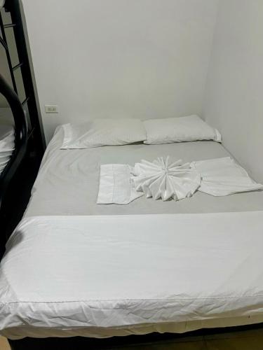 a white bed with white sheets and pillows on it at Villa getsemani in Melgar