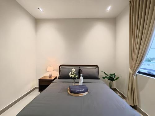 a bedroom with a bed with a blue blanket and a window at Desaru Coast, Taman Maris By Antlerzone in Bandar Penawar