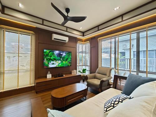 a living room with a couch and a tv at Desaru Coast, Taman Maris By Antlerzone in Bandar Penawar