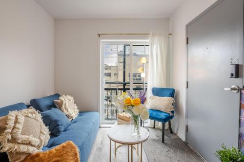 a living room with a blue couch and a table at Modern 3BR in Griffintown in Montréal