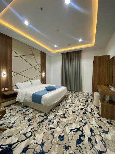 a bedroom with a large bed and a large rug at بالمز للشقق المخدومه in Sufan