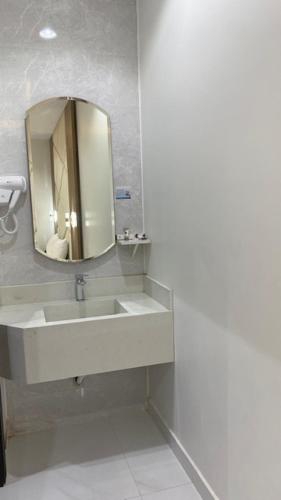 a bathroom with a sink and a mirror at بالمز للشقق المخدومه in Sufan