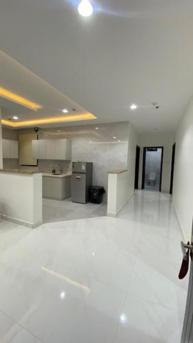 a large room with white floors and a kitchen at بالمز للشقق المخدومه in Sufan