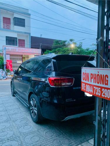 a car parked next to a sign on a street at Nhà nghỉ Lộc Thiên 1 in Ấp Rạch Mẹo