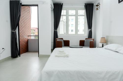 a bedroom with a white bed and a window at Ân Coffee in Hanoi