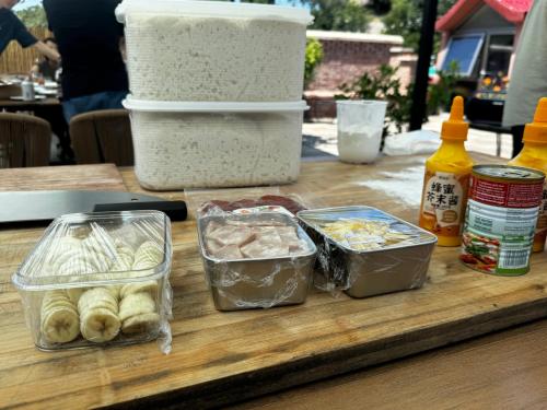 a table topped with containers of food on a table at Beijing MutianyuGreat Wall Let'sgo Hotel&Bar in Huairou