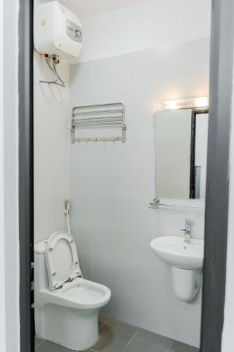 a white bathroom with a toilet and a sink at Ân Coffee in Hanoi